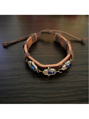Brown leather bracelet with adjustable straps and silver hamsa charms with blue